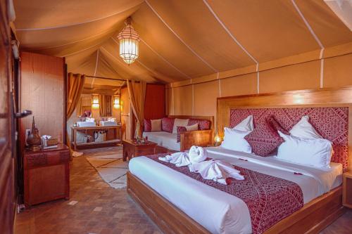 马拉喀什梅尔霍恩摩洛哥传统庭院旅馆及Spa的帐篷内一间卧室,配有一张大床