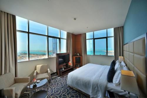 阿布扎比阿布扎比滨海路华美达酒店的酒店客房设有一张床、一台电视和窗户。