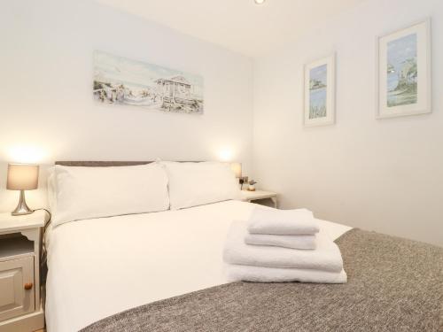 莫珀斯Canny Cottage的卧室配有白色床和毛巾