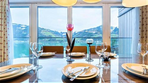 滨湖采尔Alpin & See Resort - Pinzgau Holidays的一间带桌子和大窗户的用餐室