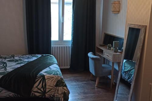 迪塞Petite maison de bourg proche A84的一间卧室配有一张床、一张书桌和一个窗户。