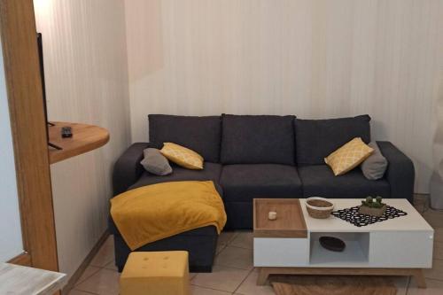 迪塞Petite maison de bourg proche A84的客厅配有蓝色的沙发和桌子