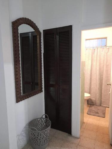 圣胡安Hermoso Apartamento frente Aeropuerto de Isla Verde的浴室设有黑色门和镜子