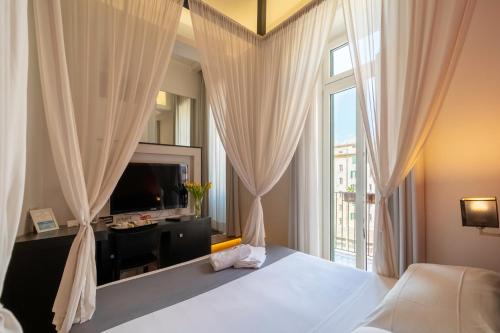 罗马菲利伯托家庭城镇酒店的一间卧室设有一张床和一个大窗户