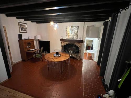 Gargilesse-DampierreCharmante maison berrichonne的客厅配有桌子和壁炉