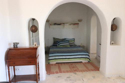 斯法克斯Villa Naïa Domaine Béluga Bounouma kerkennah的一间卧室配有一张床和一架钢琴