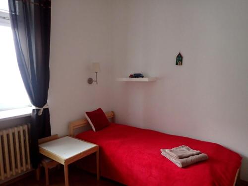 布拉迪斯拉发Superior apartment的窗户客房内的一张红色小床