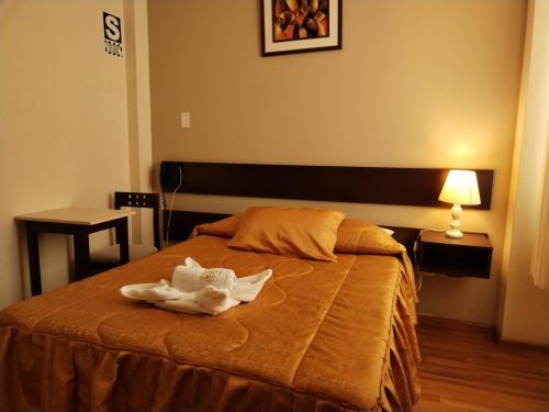 塔克纳Hotel Dubái的一间卧室配有一张床,床上有毛巾