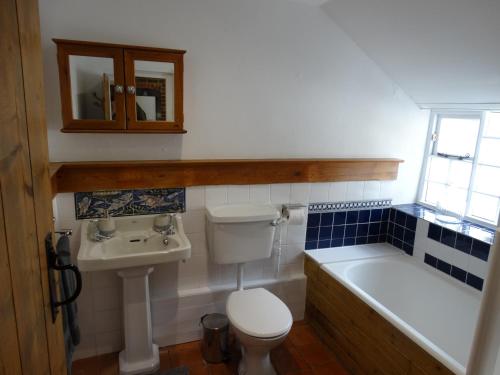 布里德波特Staddlestones Cottage的浴室配有卫生间、盥洗盆和浴缸。