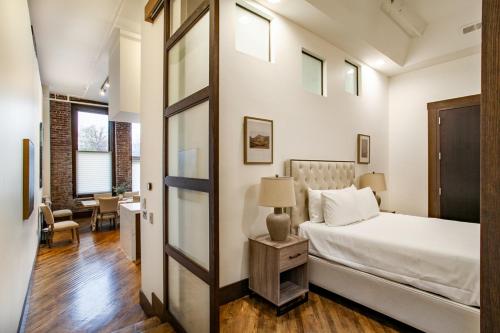 诺克斯维尔Jackson Jewel - Downtown Suite的一间卧室配有一张床和一张带台灯的桌子