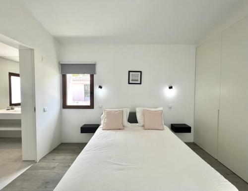 维拉摩拉Vila Ruby - Private Pool by HD PROPERTIES的白色卧室配有带粉红色枕头的大床