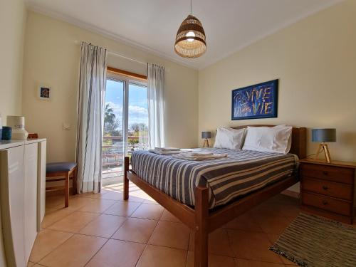 卡巴纳斯·德·塔维拉Pé na Areia的一间卧室设有一张床和一个大窗户