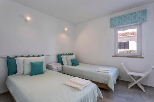 韦尔都勒博Villa Isabel的一间卧室设有两张床和窗户。