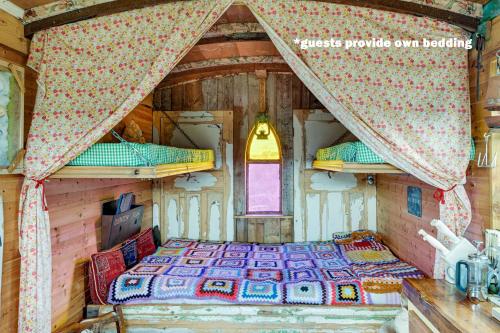 斯卡伯勒Glamping Wagon - 1 x Double Bed 2 x Single Bed的小木屋内一间卧室,配有一张床