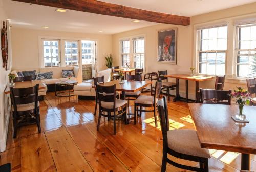 纽波特港湾酒店的一间铺有木地板并配有桌椅的用餐室