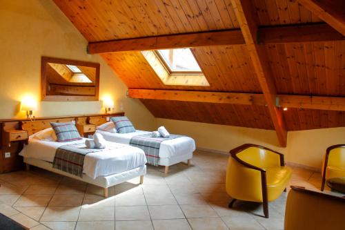 拉萨尔莱阿尔佩Hôtel Mont Thabor Serre Chevalier的一间卧室配有两张床和一张黄色椅子