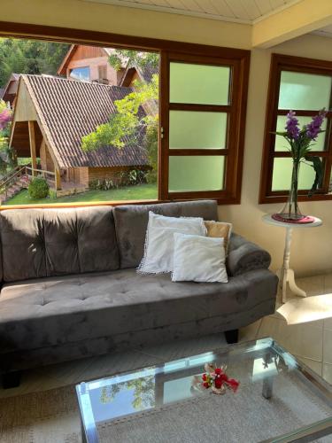 多明戈斯马丁斯Chalé Vista Azul的带沙发和玻璃桌的客厅