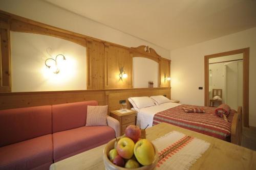 布雷斯高山客栈酒店的酒店客房设有一张沙发,桌子上放着一碗水果