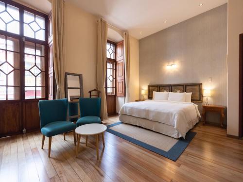 基多卡萨埃尔艾登住宿加早餐旅馆的一间卧室配有一张床、两把椅子和一张桌子