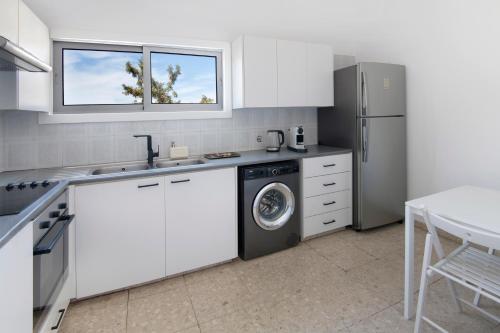 尼科西亚Urban Condo 12 - 2 Bdr的厨房配有白色橱柜、洗衣机和烘干机