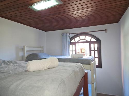 佩德拉阿祖尔LarDoceFesta Home的一间卧室设有三张床和窗户。