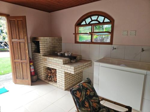 佩德拉阿祖尔LarDoceFesta Home的厨房配有砖炉和窗户