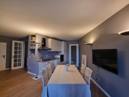 比索内Lake Apartment 3的一间带桌椅的厨房和一台电视