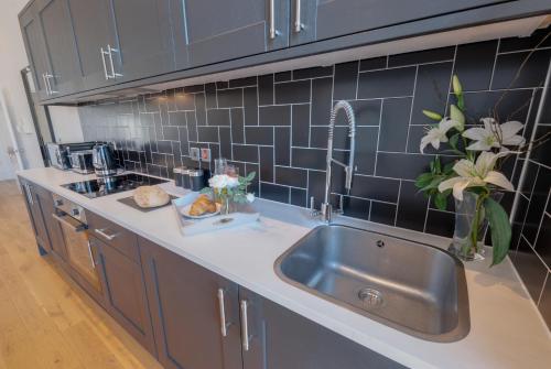 利物浦80 by Elite的厨房配有不锈钢水槽和蓝色瓷砖