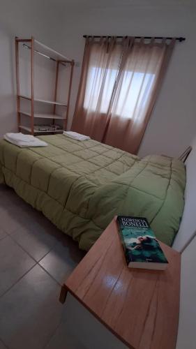 圣罗莎Departamentos A544的一间卧室,配有一张床铺,桌子上放着一本书