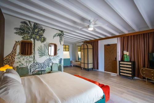 夏洛特阿马利亚The Pink Palm Hotel - Adults Only的卧室配有白色的床和长颈鹿壁画
