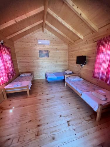 VranjinaEthno village Moraca - Skadar lake的一间设有三张床和一台电视的房间