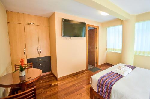 胡利亚卡Samkauta Hotel & Suite的酒店客房配有一张床铺和一张桌子。
