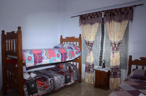 El CarmenApartamentos Naomi的一间卧室配有两张双层床和一张婴儿床。