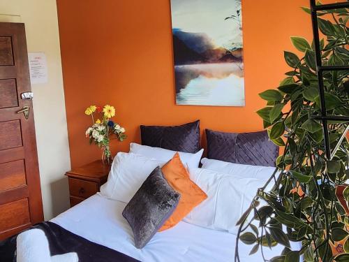 GarstonThe Garston Lodge的一间卧室配有一张白色的床和橙色的墙壁