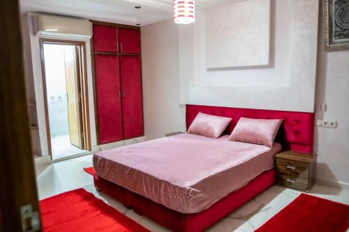 阿加迪尔Riad dar asalam的一间卧室配有红色的床和红色床头板