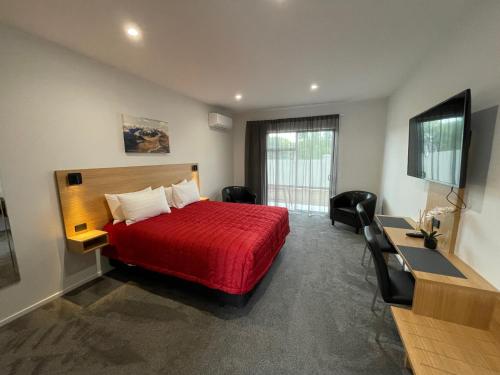 奥玛拉玛塞拉汽车旅馆及公寓的酒店客房配有红色的床和电视。