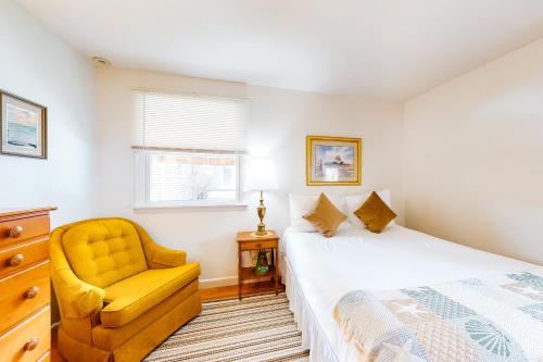 Owls HeadTideview的一间卧室配有一张床和一张黄色椅子