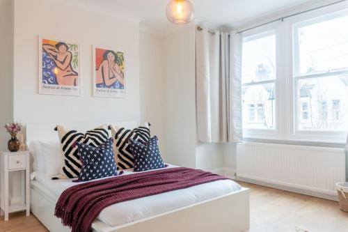 伦敦Dahomey Home - Streatham - London的白色卧室配有蓝色和白色枕头的床