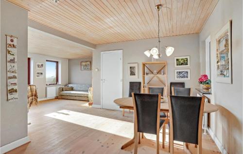 班霍尔姆Gorgeous Home In Bandholm With Kitchen的用餐室以及带桌椅的起居室。