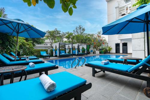 会安Hoi An Golden Holiday Hotel & Spa的一个带蓝色躺椅和遮阳伞的游泳池