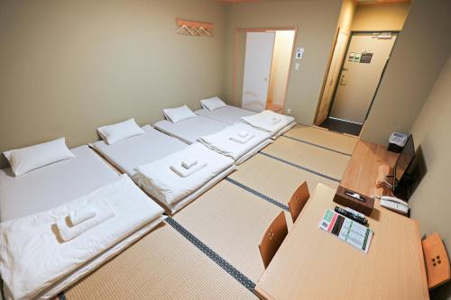 东京Akihabara Nakagawa Inn的小房间设有四张床和电视
