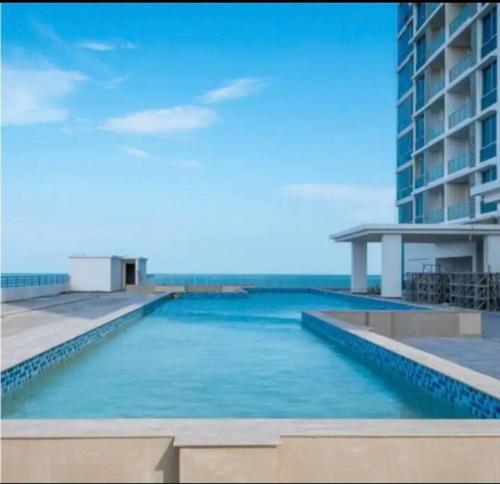 新戈尔戈纳Apto de Playa con una Hermosa vista frente al mar的大楼前的游泳池