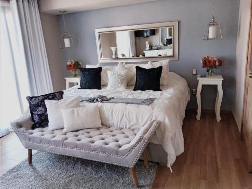 圣克里斯托瓦尔-德拉斯卡萨斯Casa Neek的一间卧室配有一张大床、一张沙发和一个镜子