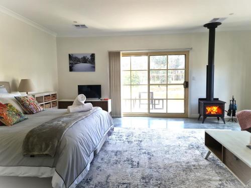 坎永莱格Canyonleigh Retreat的一间卧室设有一张大床和一个壁炉
