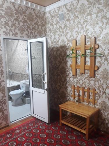 希瓦Guest House Orzu的一间带卫生间和长凳的浴室