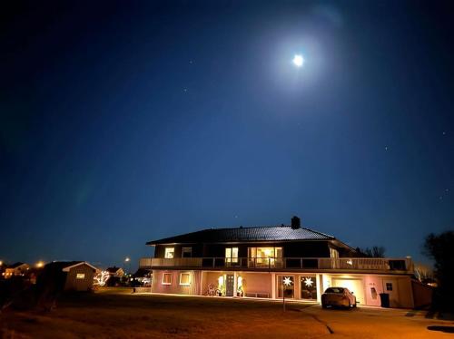 安德内斯Apartment Utsikten的天空中月亮的夜晚房屋