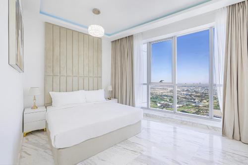 迪拜Upgraded Two Bedroom Apartment in Marina的卧室设有一张白色大床和大窗户