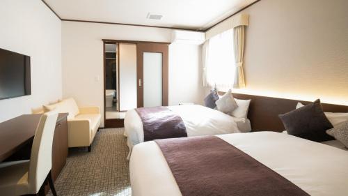 富士河口湖HOTORI no HOTEL BAN的酒店客房设有两张床和电视。