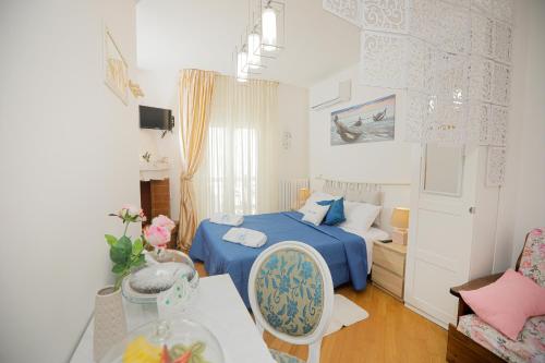 滨海波利尼亚诺Io, te e il mare的一间设有蓝色床和一张桌子的小卧室