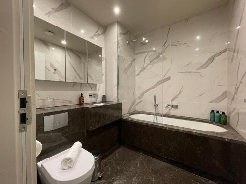 齐格威尔Stunning 2BA, 2BR Apt, Desirable Chigwell CHCL F6的带浴缸、卫生间和盥洗盆的浴室